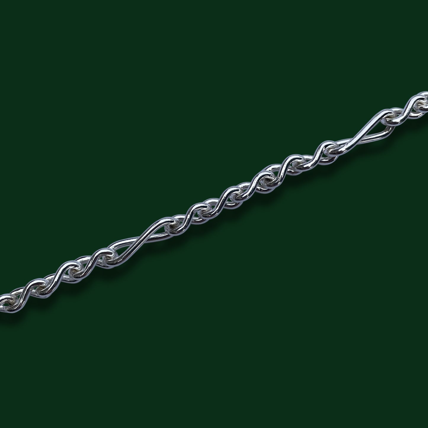 A close up on Timio's Armoni chain links on a dark green background.