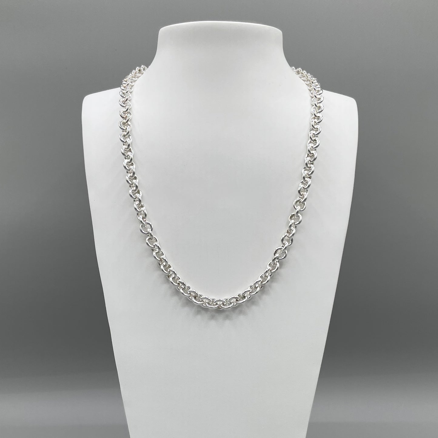 A photo of the fine silver Carnival chain displayed on a white bust in front of a grey background.