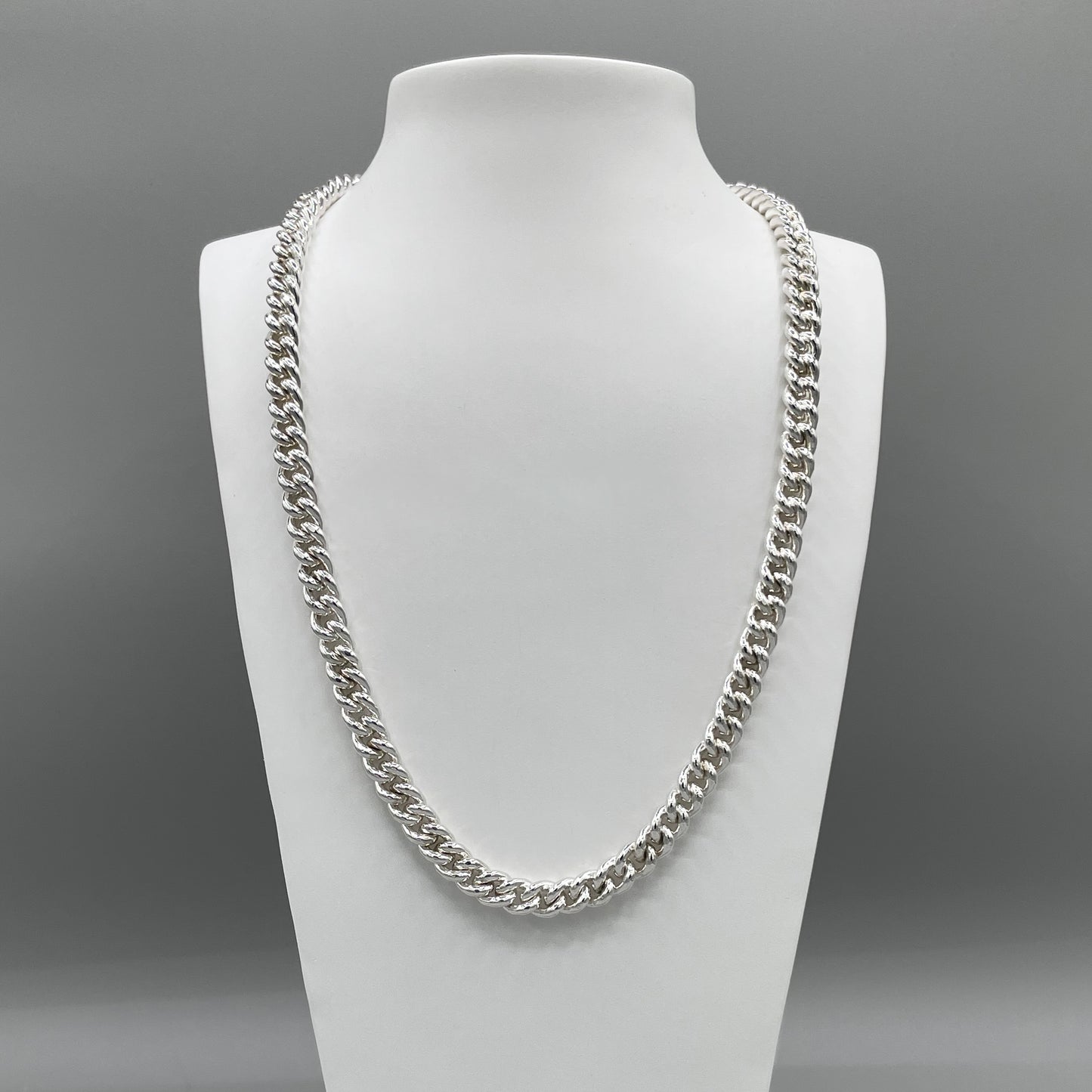 A photo of the Curb chain displayed on a white bust in front of a grey background.