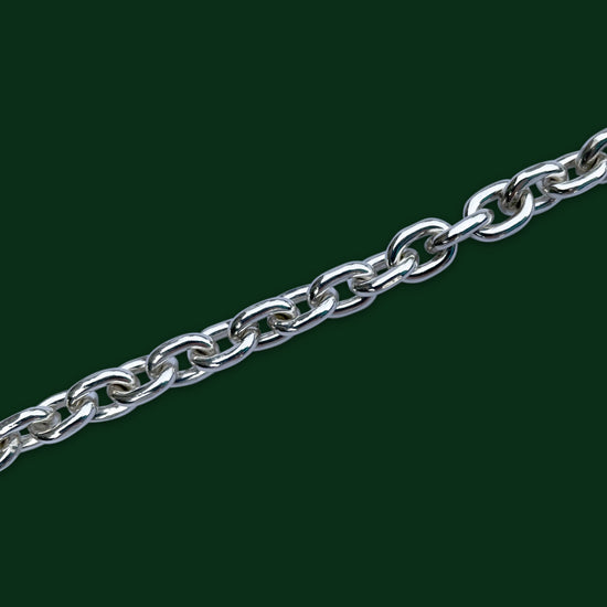 A close up of Timio's Desmo chain, in light weight, on a dark green background.