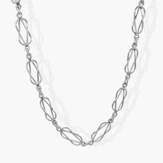 The distinctive links of the Forget-Me-Knot are formed with two loops threaded through each other to create each main link of this flat-lay chain.