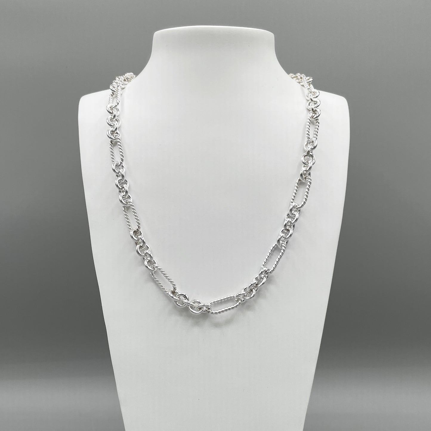 A photo of the Soiree chain in fine silver, displayed on a white bust in front of a grey background.